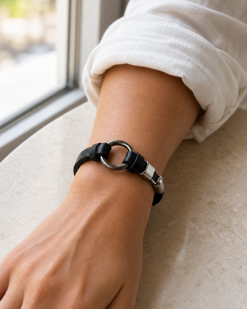 Window light detail of a woman wearing The Noir Loop Bracelet
