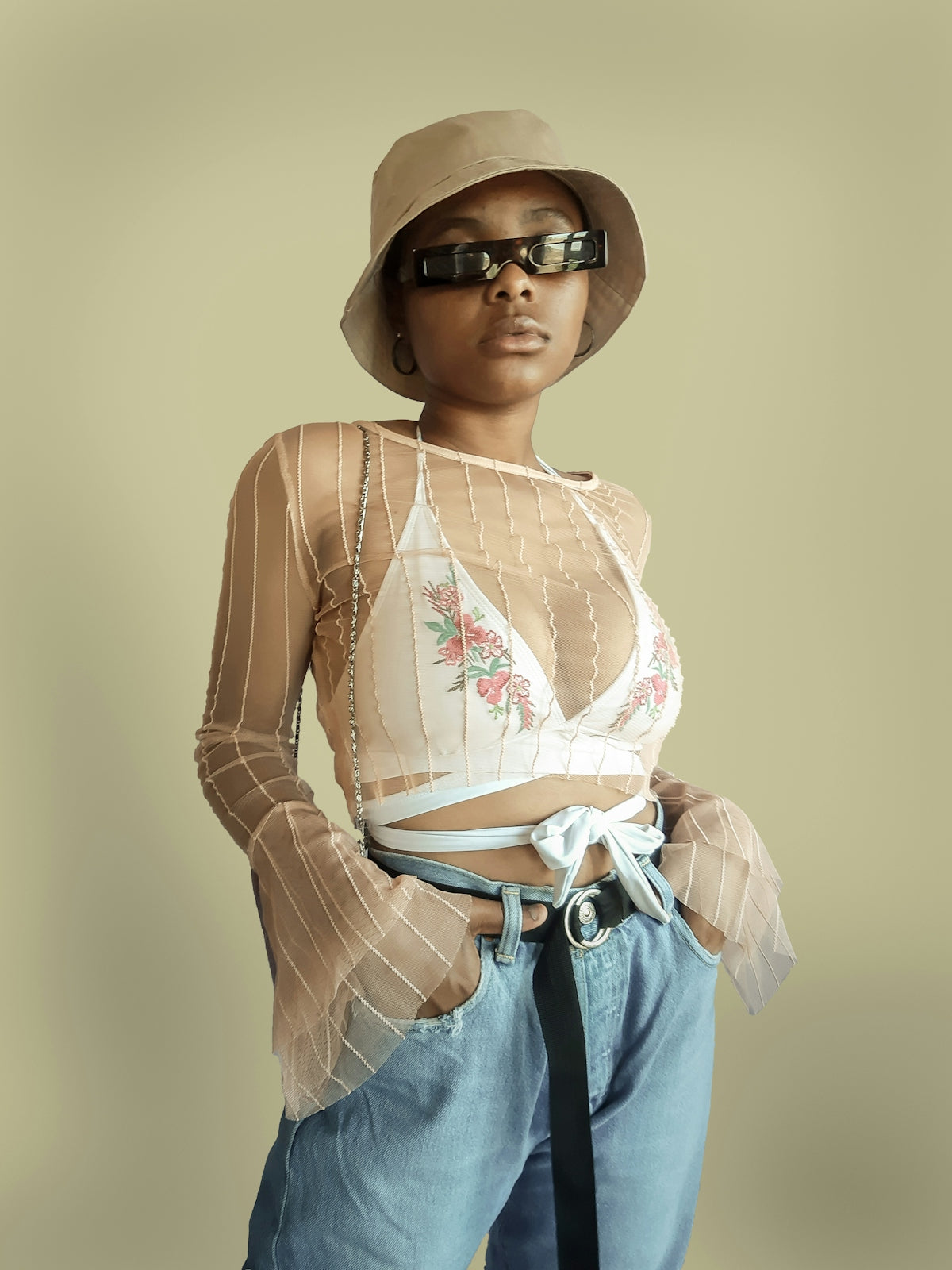 woman in white and red floral crop top and blue denim shorts wearing black sunglasses