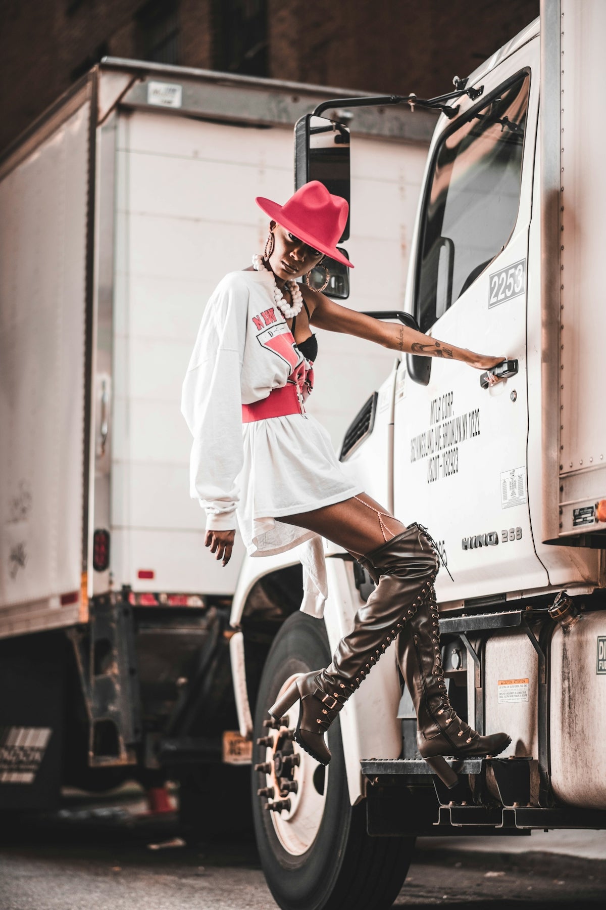 man in white and red shirt and black cowboy hat sitting on white box