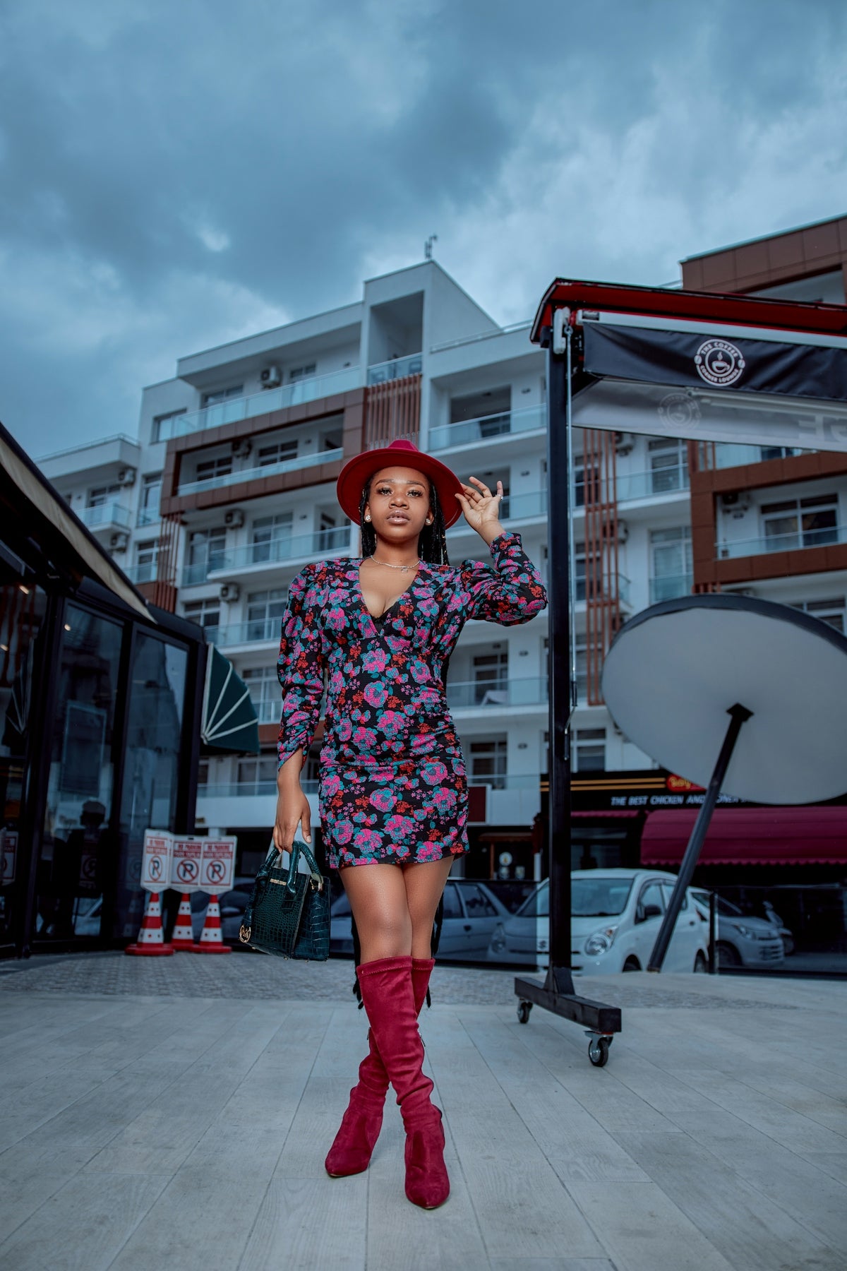 a person in a red hat and red boots standing on a sidewalk