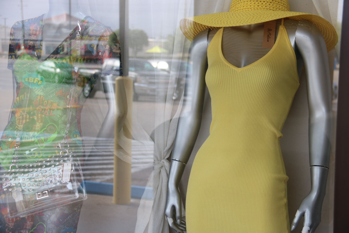 a mannequin wearing a yellow dress and a yellow hat