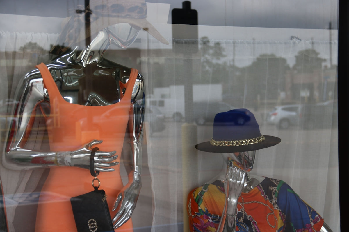 a mannequin in a window with a hat on it