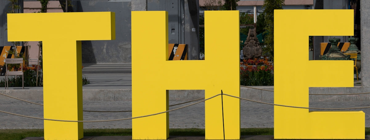 a large yellow sign sitting on the side of a road