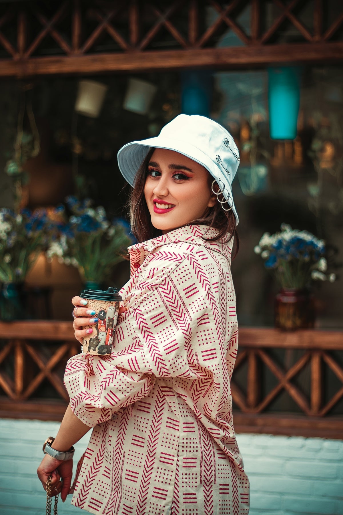 a woman in a white hat is holding a cup