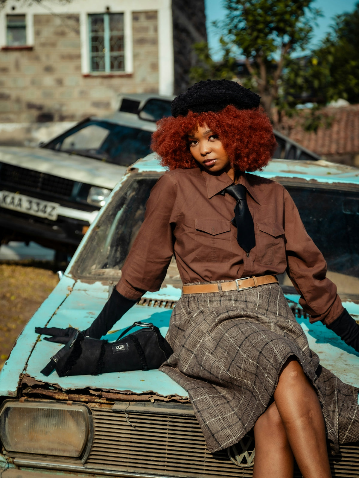 A woman with red hair sitting on top of a car