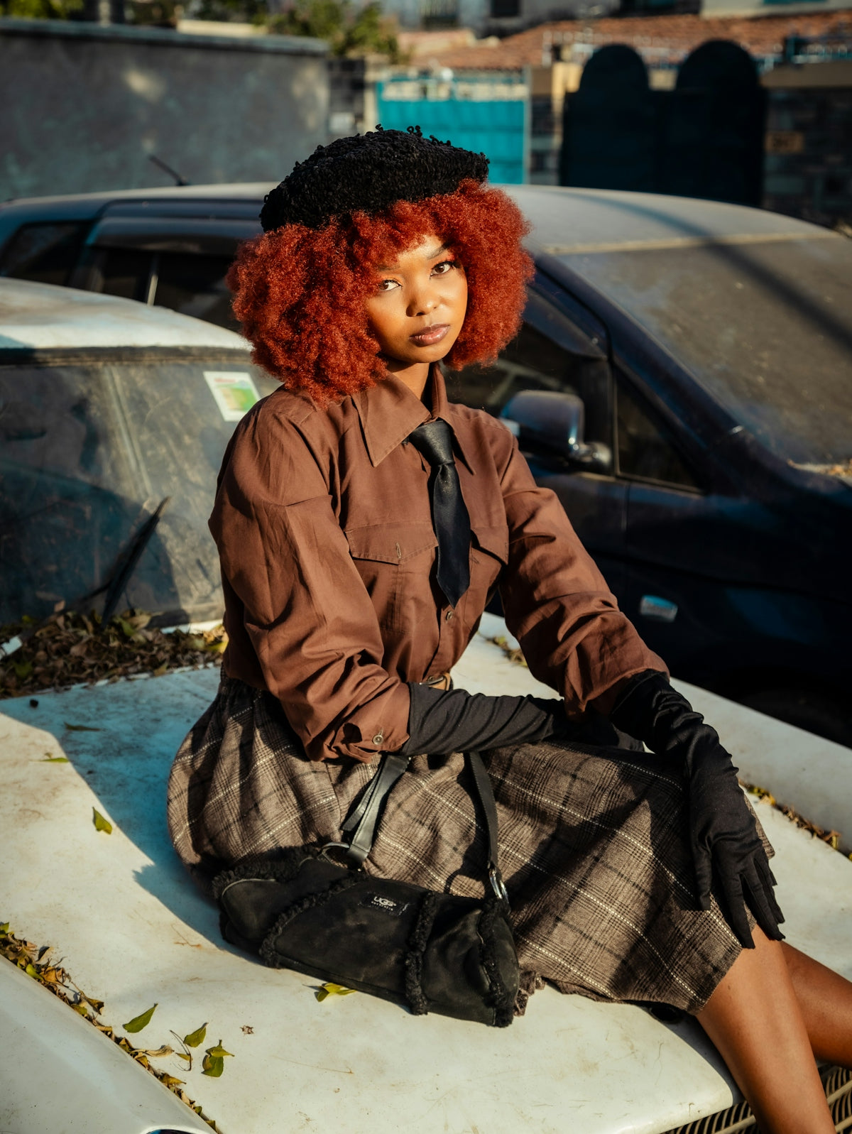 A woman with red hair sitting on top of a car