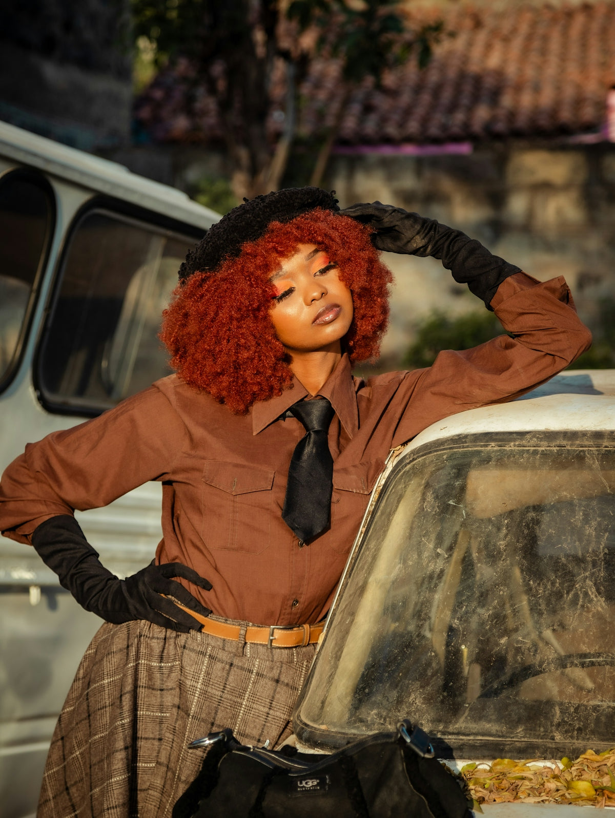 A woman with red hair standing next to a car