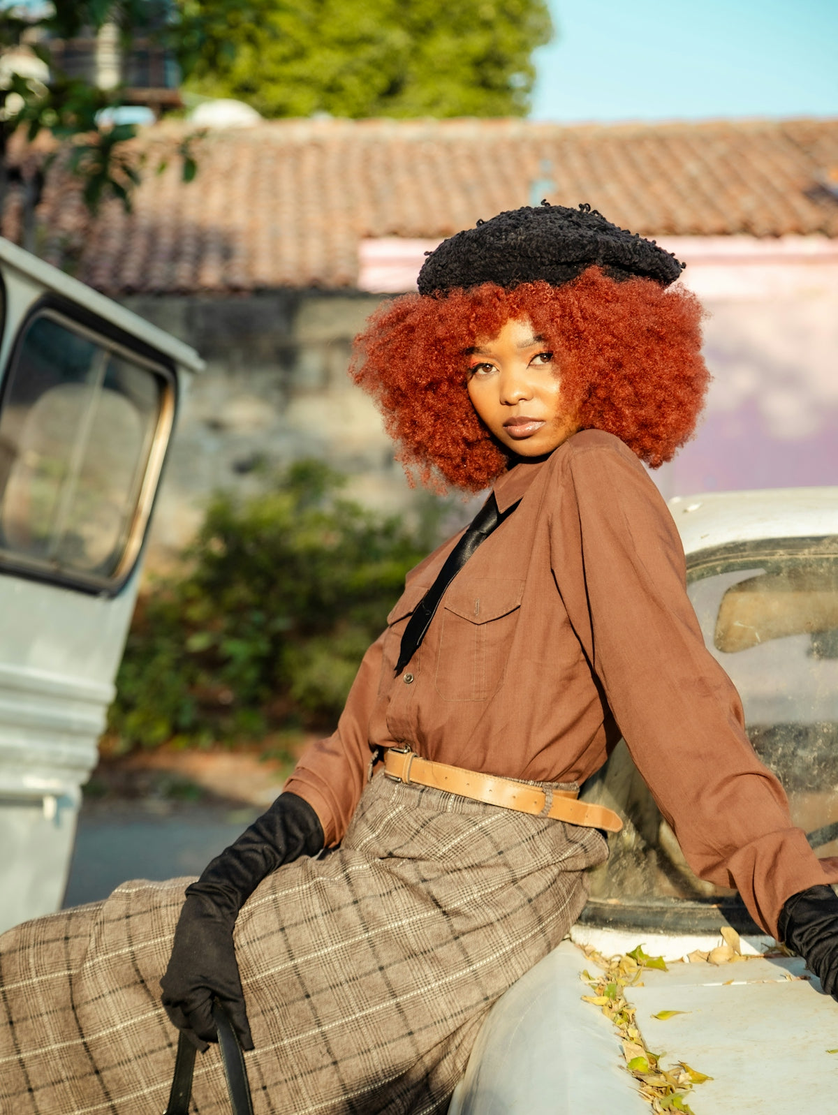A woman sitting on the hood of a car