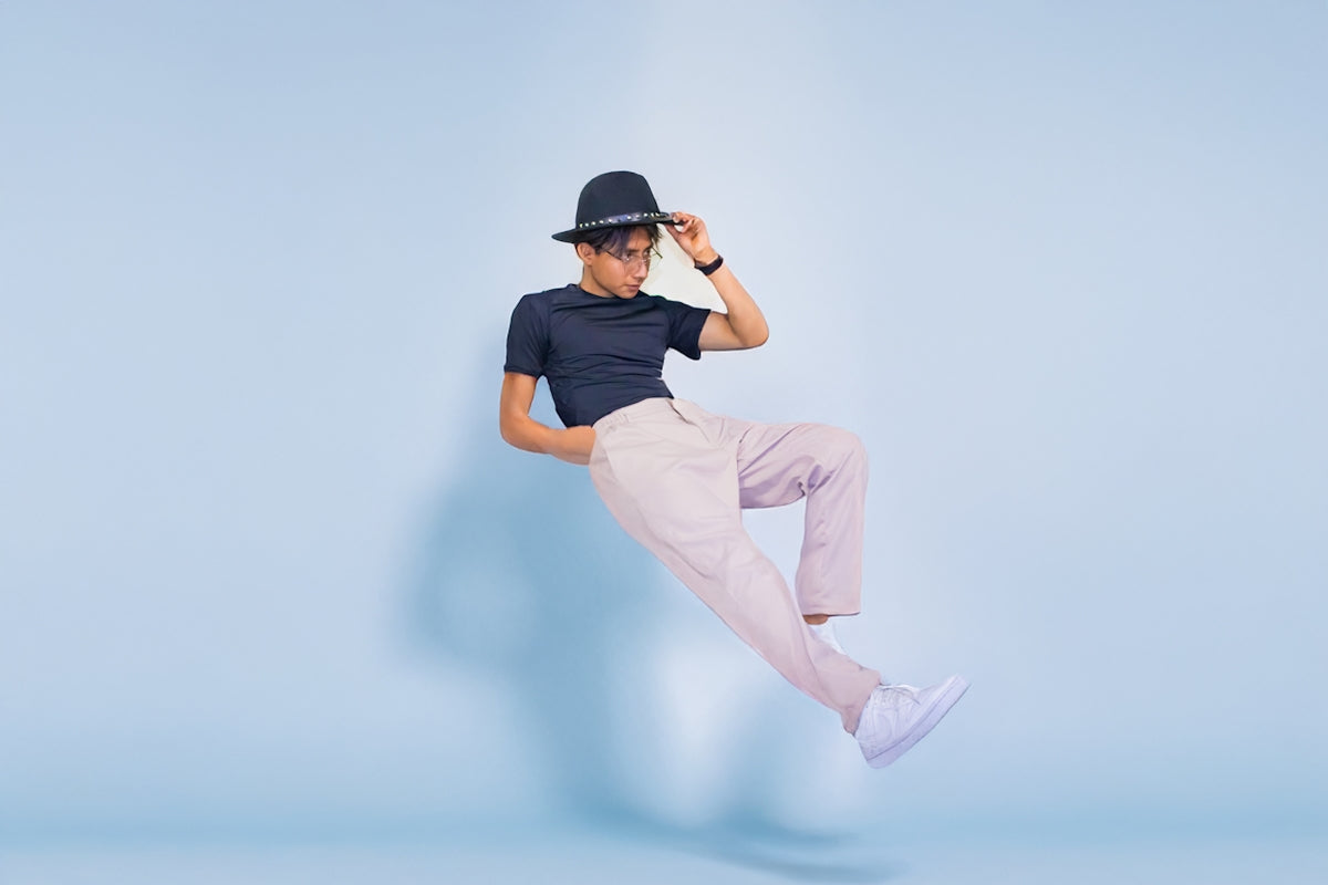 A man in a hat is jumping in the air