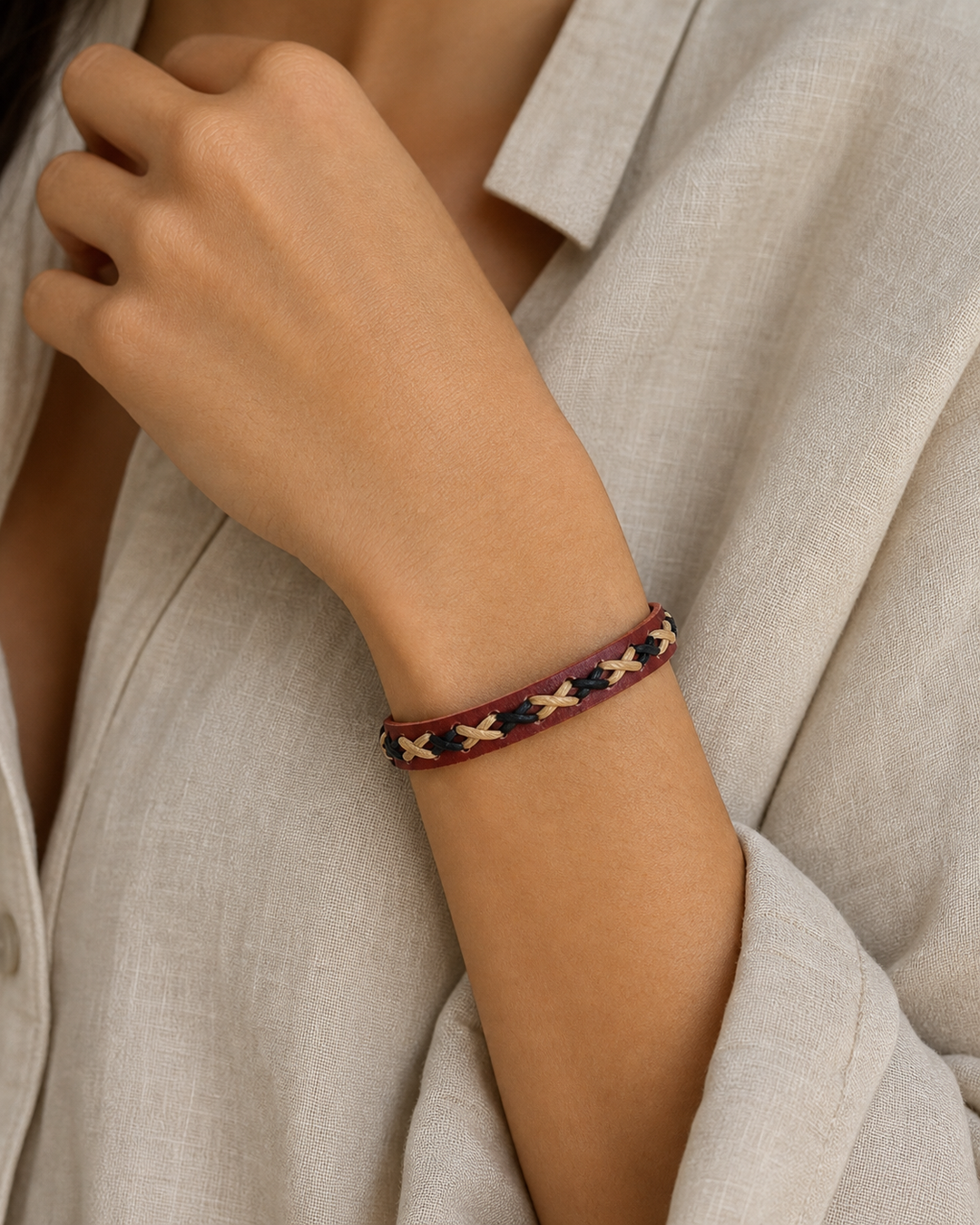 Crimson burgundy leather cuff bracelet with black and beige braided lacing on female model - view 1