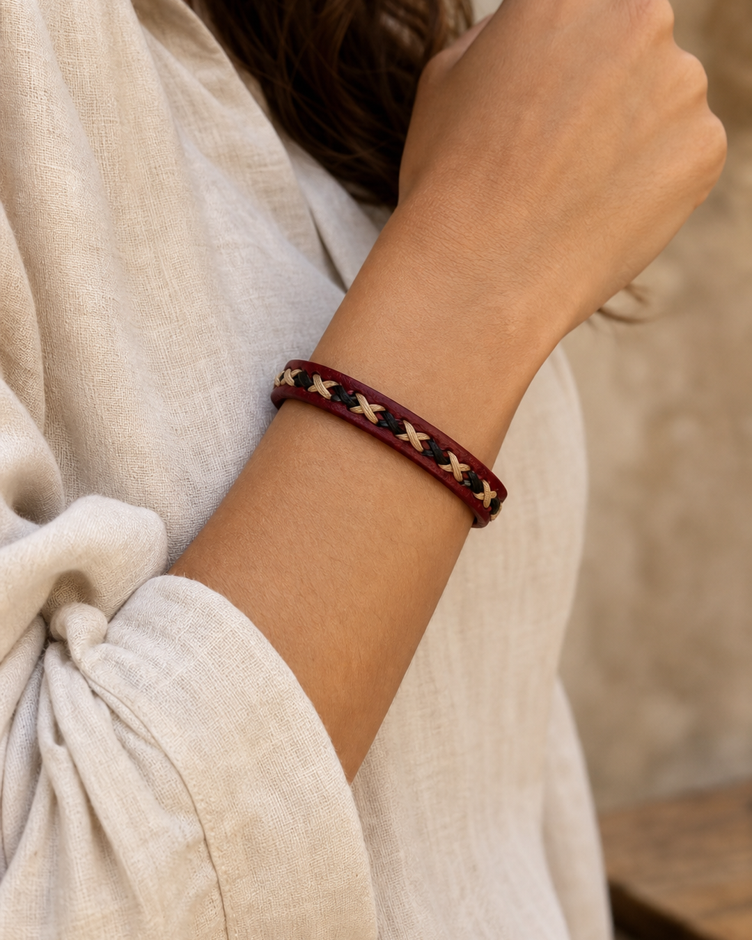 Crimson burgundy leather cuff bracelet with black and beige braided lacing on female model - view 4