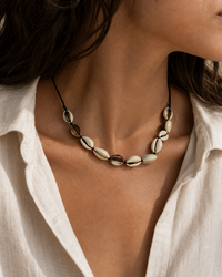 Marisca cowrie shell necklace on black cord on female model - view 1