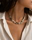 Marisca cowrie shell necklace on black cord on female model - view 1