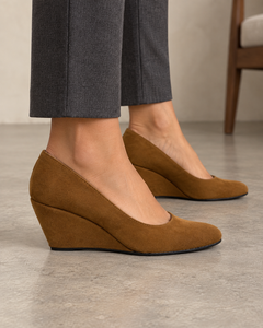 Adult woman wearing Sarabande caramel-brown wedge pumps, outside side profile showing the covered wedge