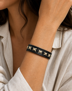 Serrin black leather cuff bracelet with cream X-stitch lacing on female model - view 1
