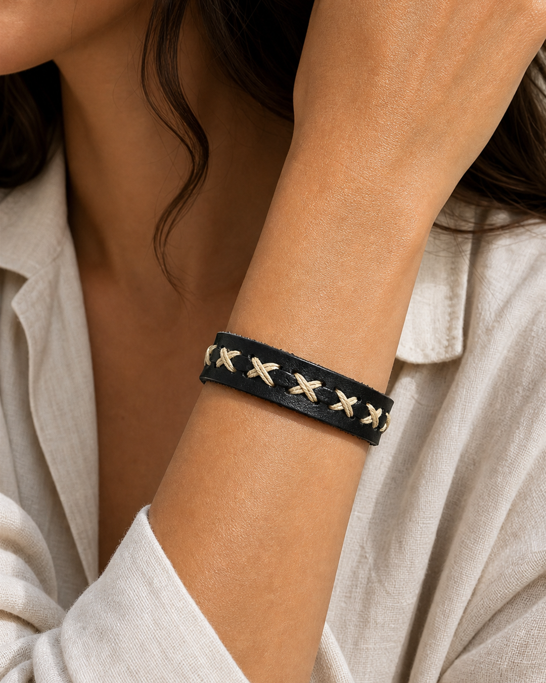 Serrin black leather cuff bracelet with cream X-stitch lacing on female model - view 1