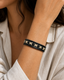 Serrin black leather cuff bracelet with cream X-stitch lacing on female model - view 1