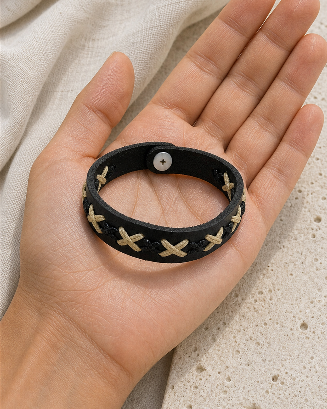 Serrin black leather cuff bracelet with cream X-stitch lacing on female model - view 3