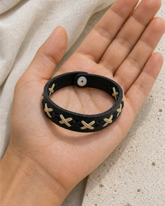 Serrin black leather cuff bracelet with cream X-stitch lacing on female model - view 3