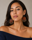 The Cognac Fringe Earrings worn by a woman in a true 4:5 front portrait