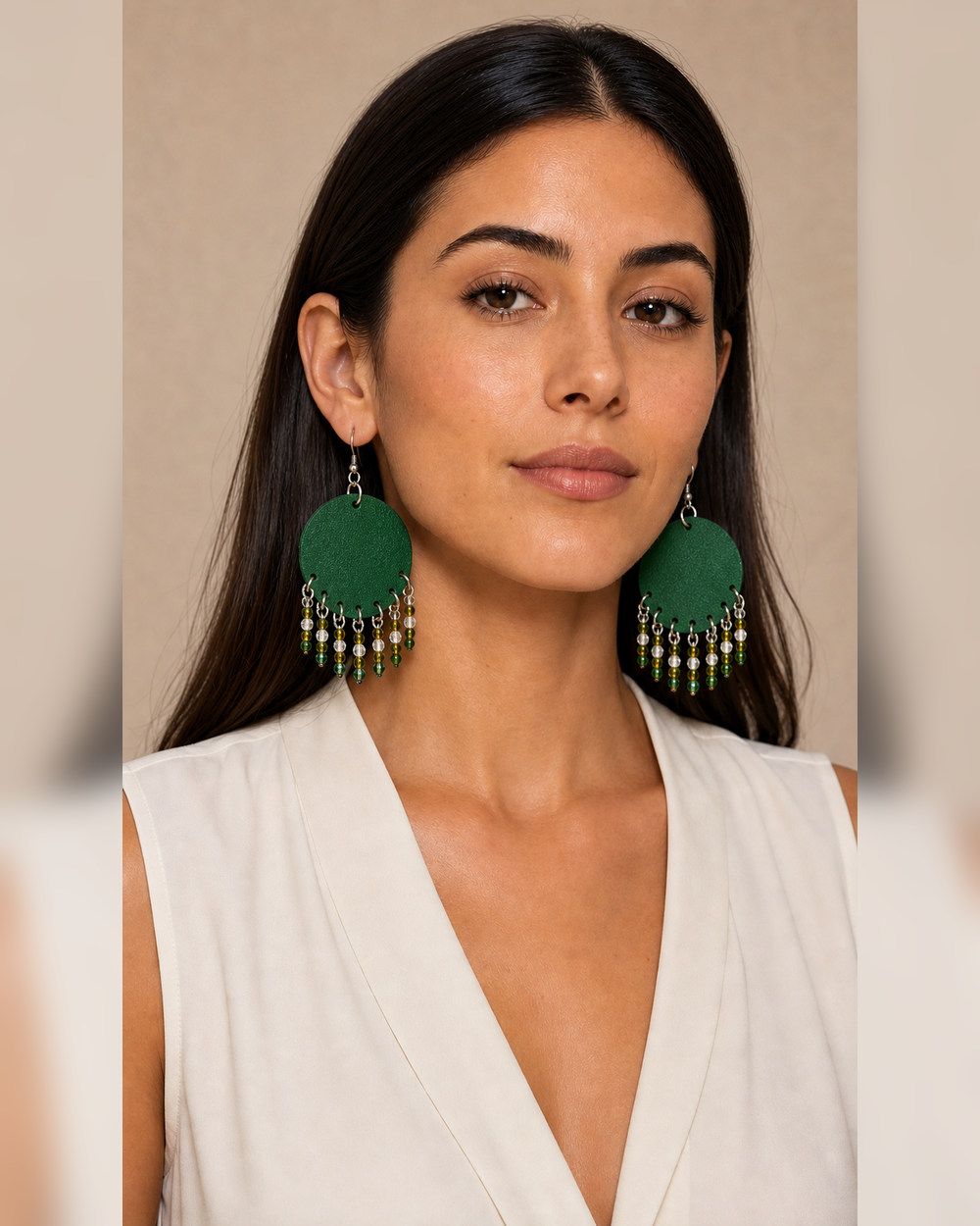 The Emerald Fringe Earrings worn by a woman in a front portrait