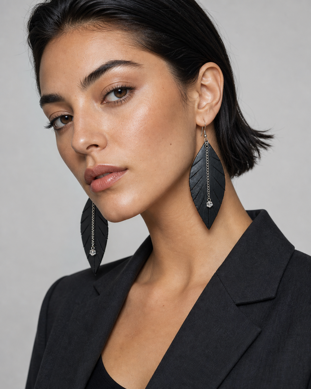 The Noir Leaf Earrings worn by a model in a studio portrait