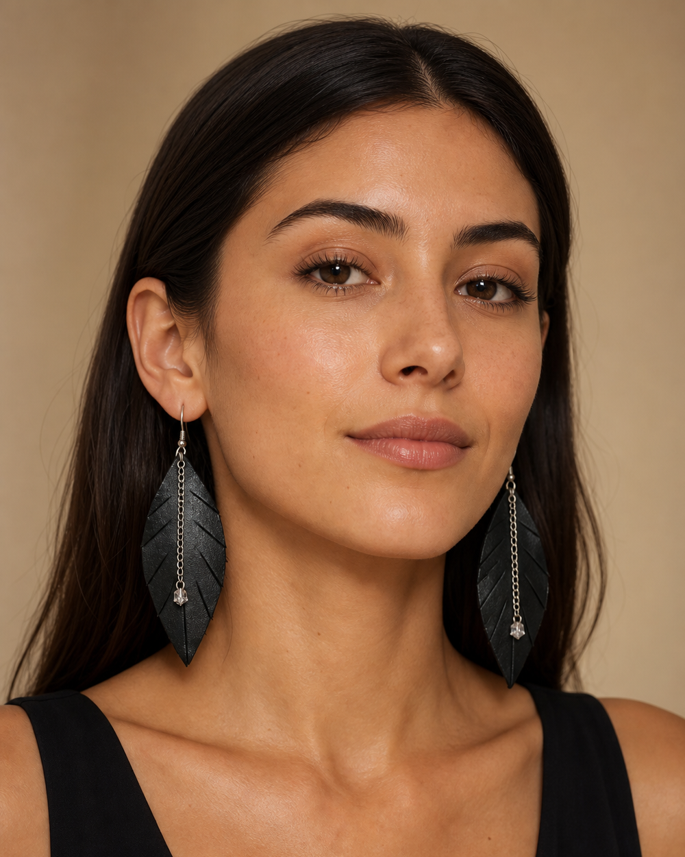 Studio portrait of model wearing black leather leaf earrings