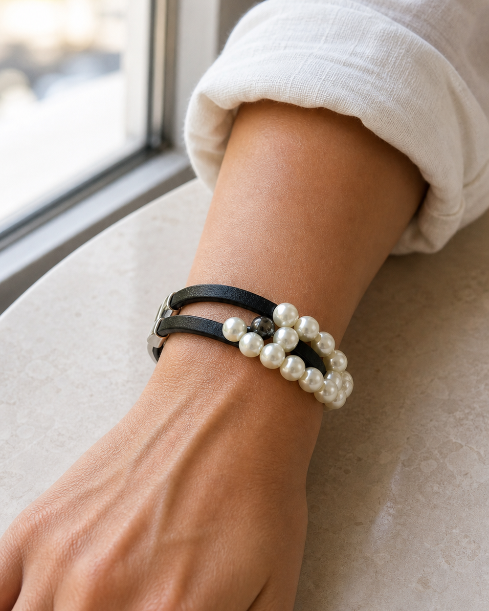 Window light detail of a woman wearing The Noir Pearl Bracelet