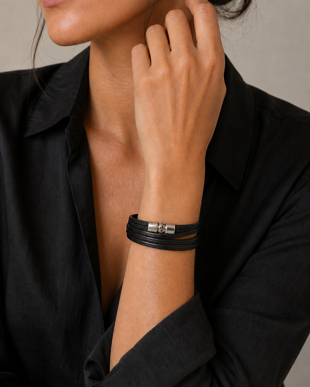 The Noir Wrap Bracelet worn by a woman in a black studio wrist portrait