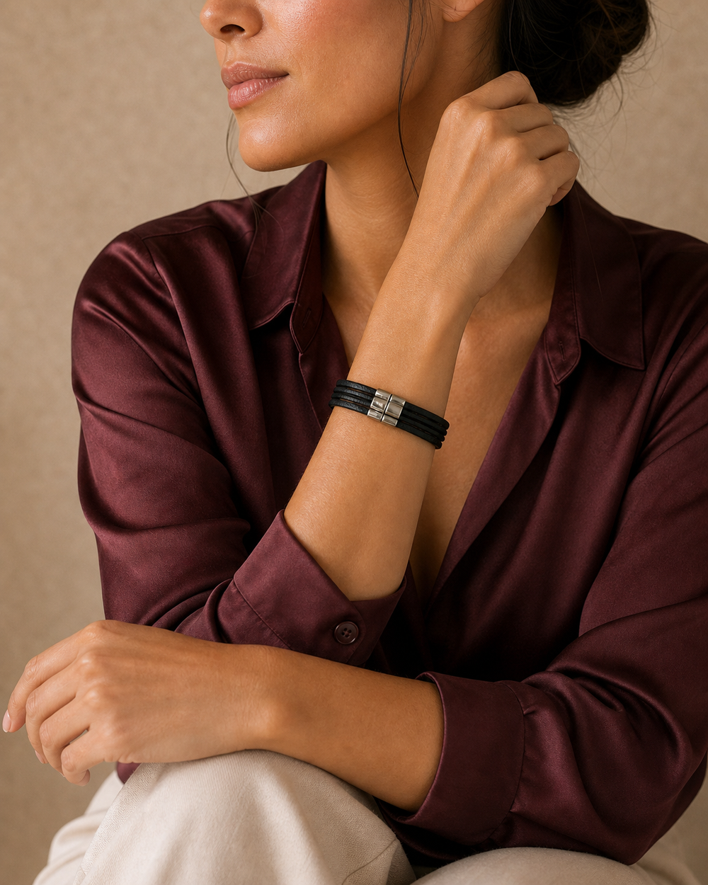 Burgundy studio portrait of a woman wearing The Noir Wrap Bracelet